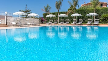 Una piscina techada, una piscina al aire libre de temporada, sombrillas