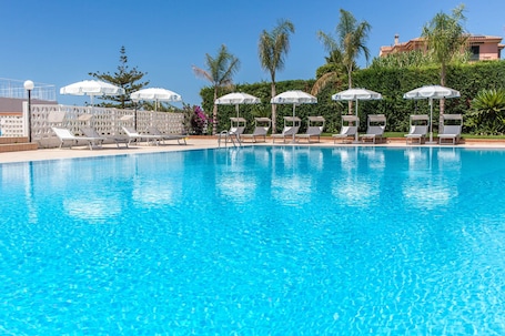 Una piscina techada, una piscina al aire libre de temporada, sombrillas