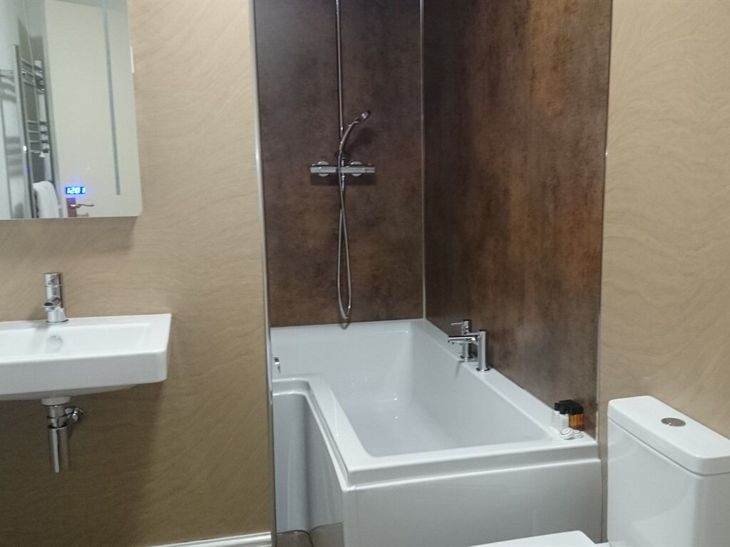 Un baño con lavamanos blanco, bañera y retrete.