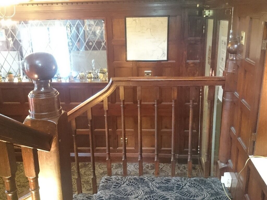 A wooden staircase with a balustrade leading to a landing.