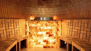Una sauna con pared de ladrillo y bancos de madera.