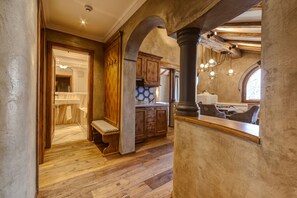 A spacious kitchen with wooden cabinets, a built-in bench, and a large window. - BelArosa Hotel (Arosa)