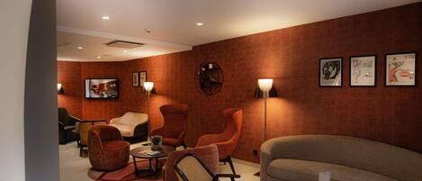 A modern lounge area with a sofa, armchairs, a coffee table, and a floor lamp.