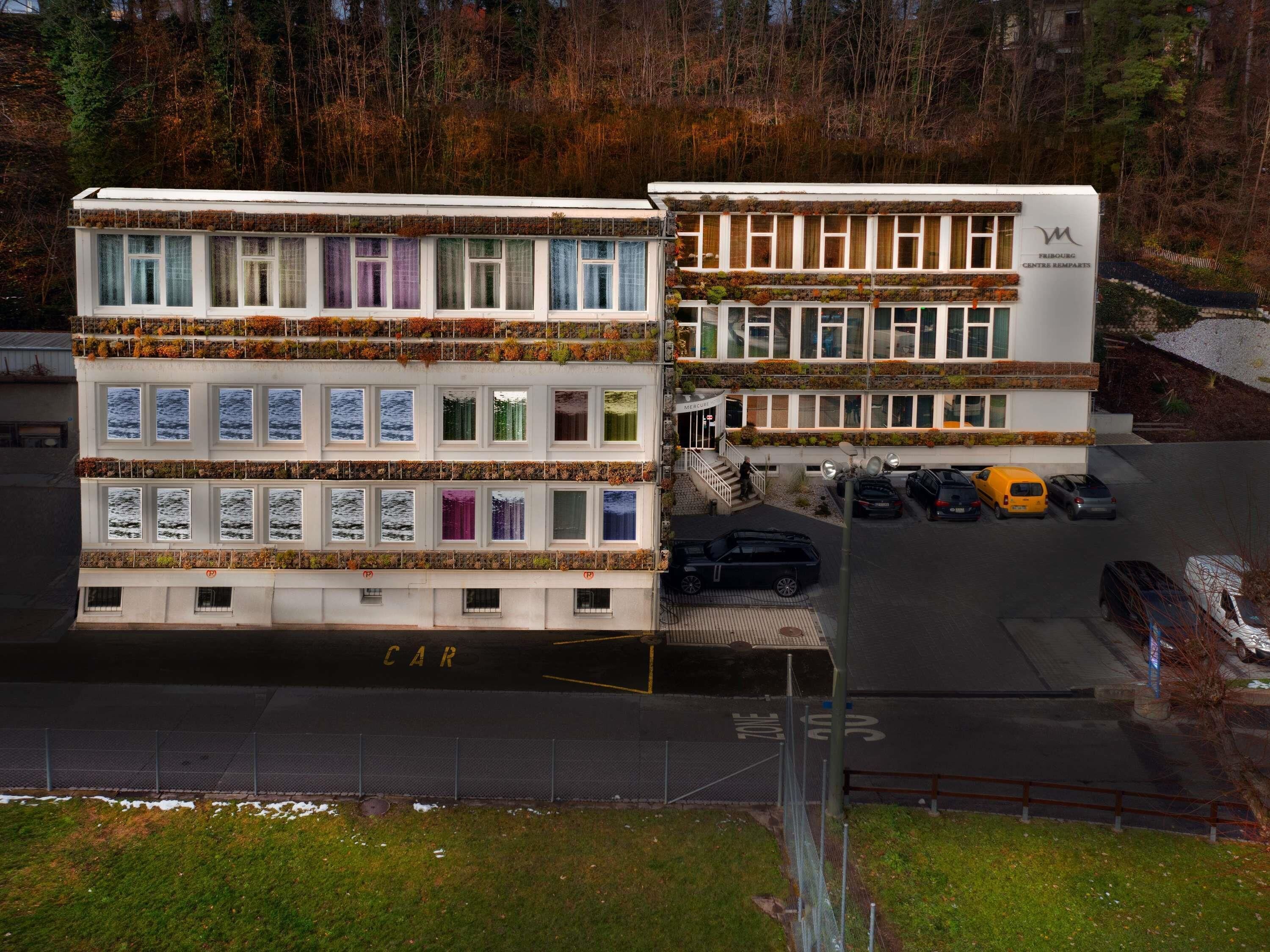 A multi-story building with a parking area in front.