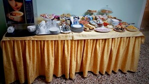 A buffet table with various food items and a coffee machine.