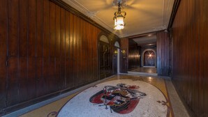A long, wooden hallway with a carpeted floor and a coat of arms design.