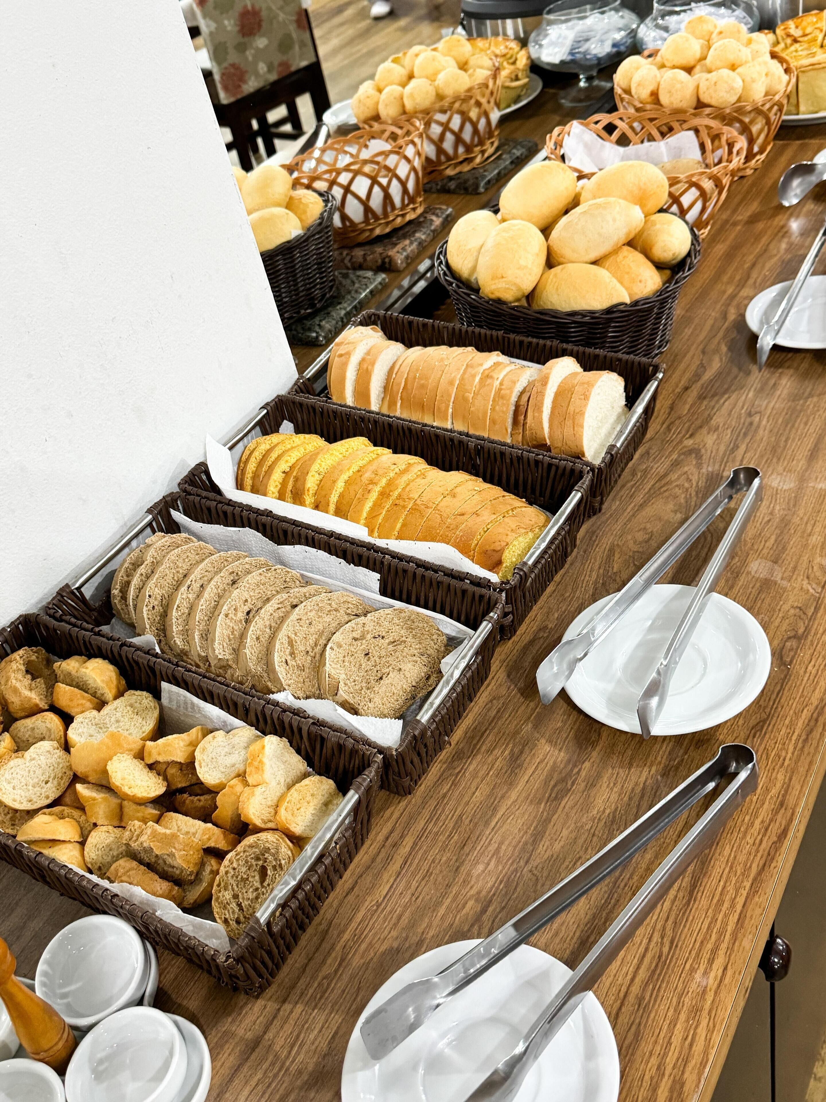 Un bufé con panes y pasteles varios.