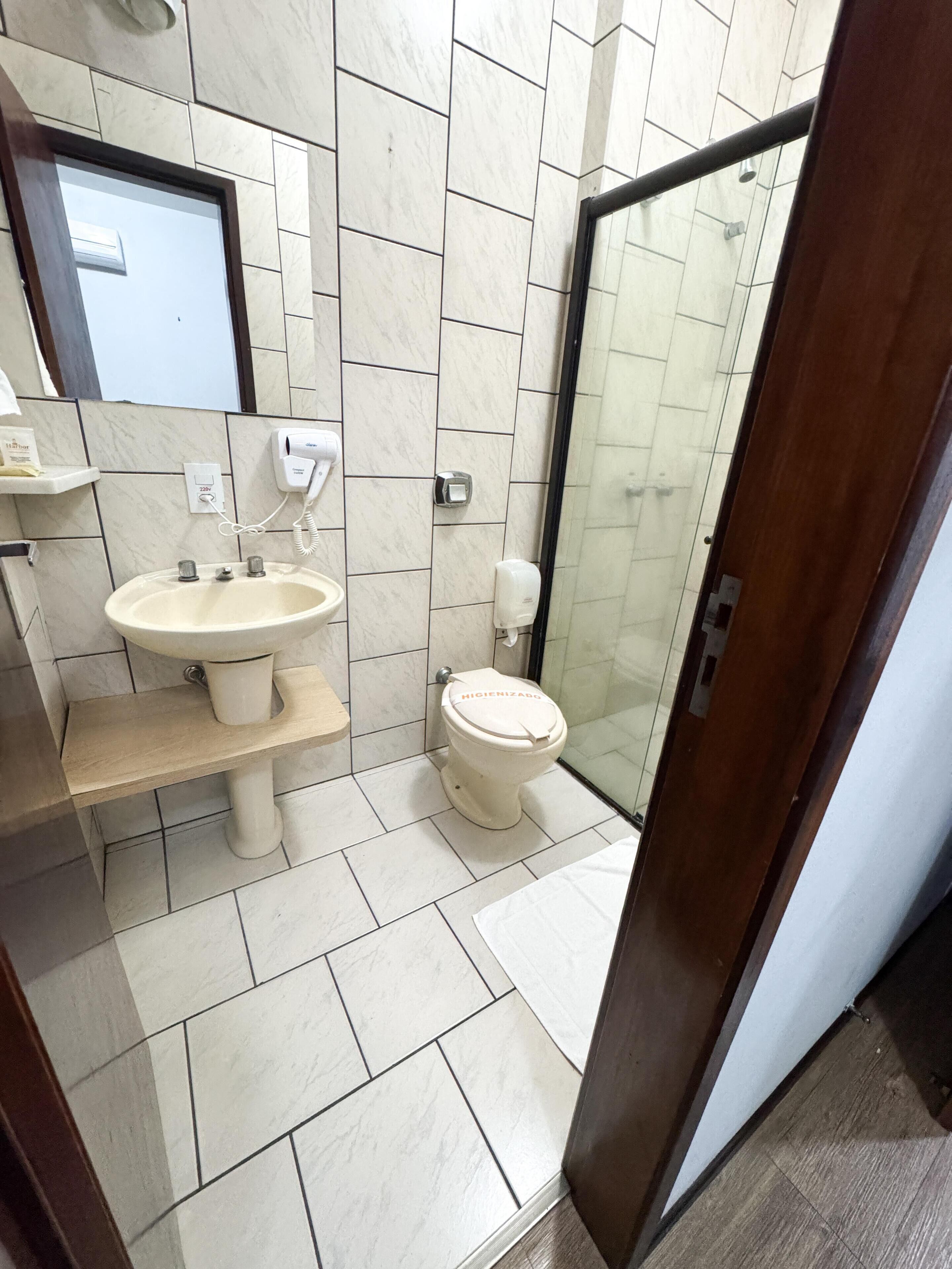 Une salle de bain équipée d’un lavabo, de toilettes et d’une douche à parois en verre.