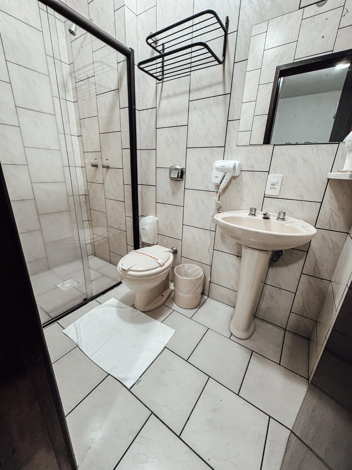 Ein Badezimmer mit Toilette, Bidet, Waschbecken und Duschbereich.