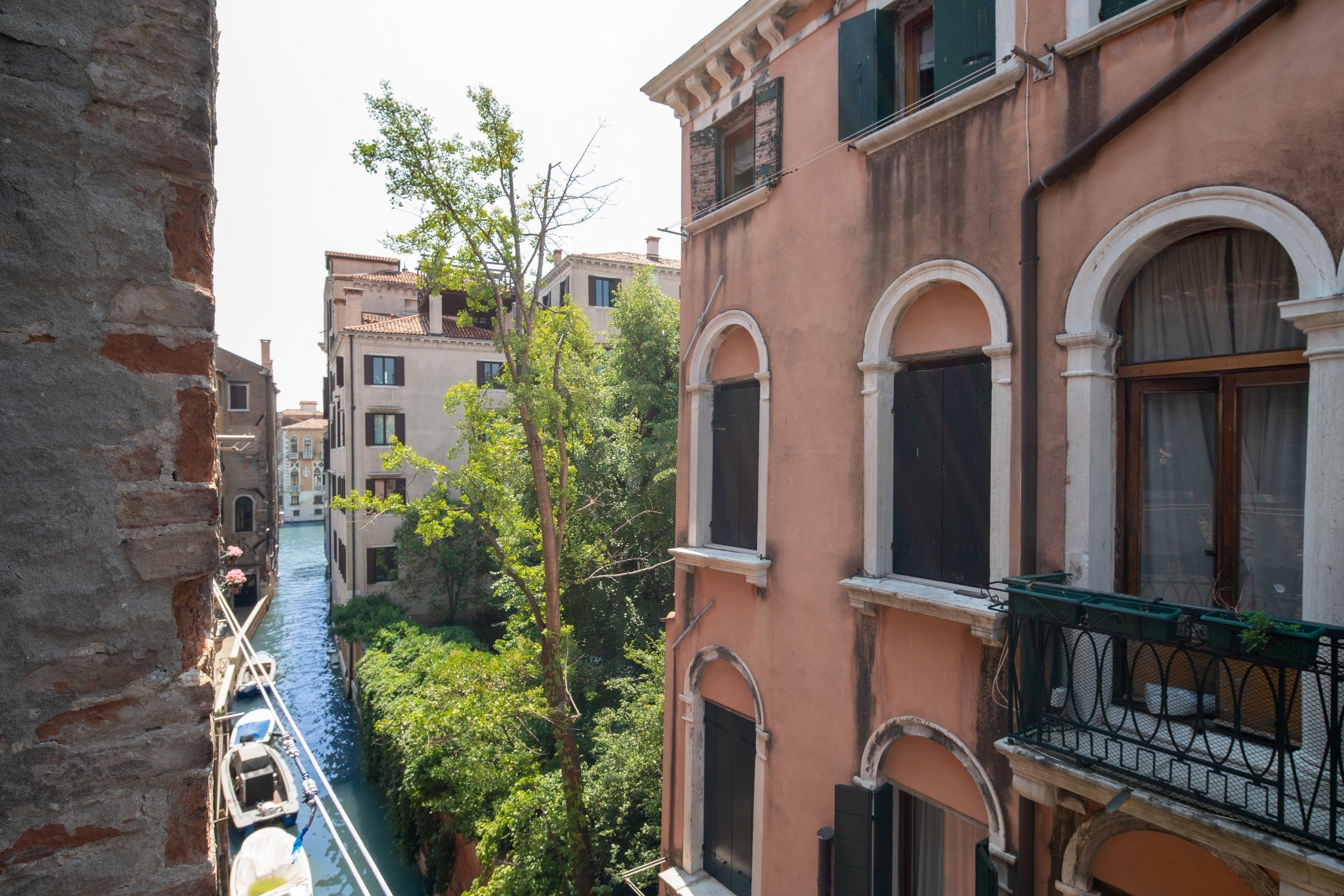 A narrow canal flanked by historic buildings with arched windows and balconies.