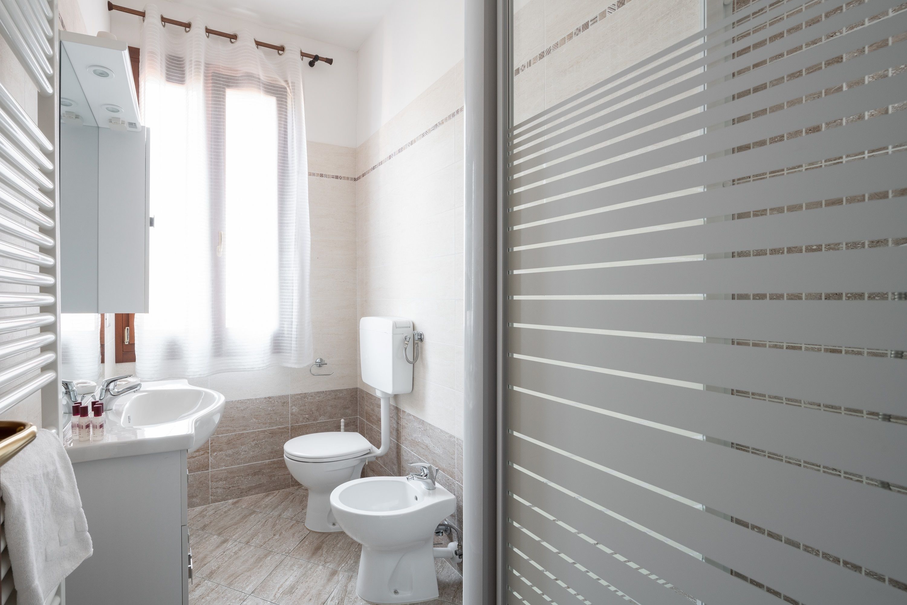 Et moderne badeværelse med toilet, bidet og vask.