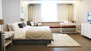 A modern hotel room with a bed, bedside tables, a desk, and a television. - Polaris Hotel (Bucheon)