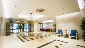 A spacious lobby with a marble floor, a reception desk, and seating areas. - Polaris Hotel (Bucheon)