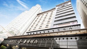 A hotel with a modern facade, large windows, and a prominent entrance with illuminated signage. - Polaris Hotel (Bucheon)