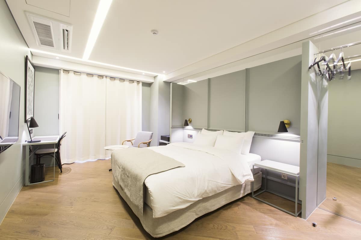 Una habitación de hotel moderna con una cama grande, un escritorio y una silla.