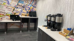 A kitchen area with a map on the wall, a coffee machine, and a laptop on a table. - La Quinta Inn & Suites by Wyndham Tulsa Midtown (Tulsa)