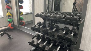 A gym with multiple sets of dumbbells arranged on racks, a treadmill, and exercise balls. - La Quinta Inn & Suites by Wyndham Tulsa Midtown (Tulsa)