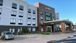 A hotel with a modern facade, a prominent 'La Quinta' sign, and a parking lot with marked handicapped spaces. - La Quinta Inn & Suites by Wyndham Tulsa Midtown (Tulsa)