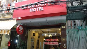 A hotel entrance with a red sign, a visible phone number, and a number 15 on the gate. - Hanoi Charming House (Hanoi)