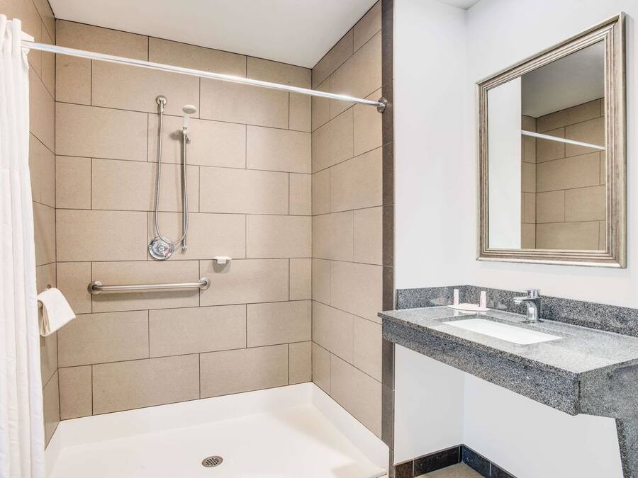 Een moderne badkamer met een inloopdouche, een wastafelmeubel en een spiegel.