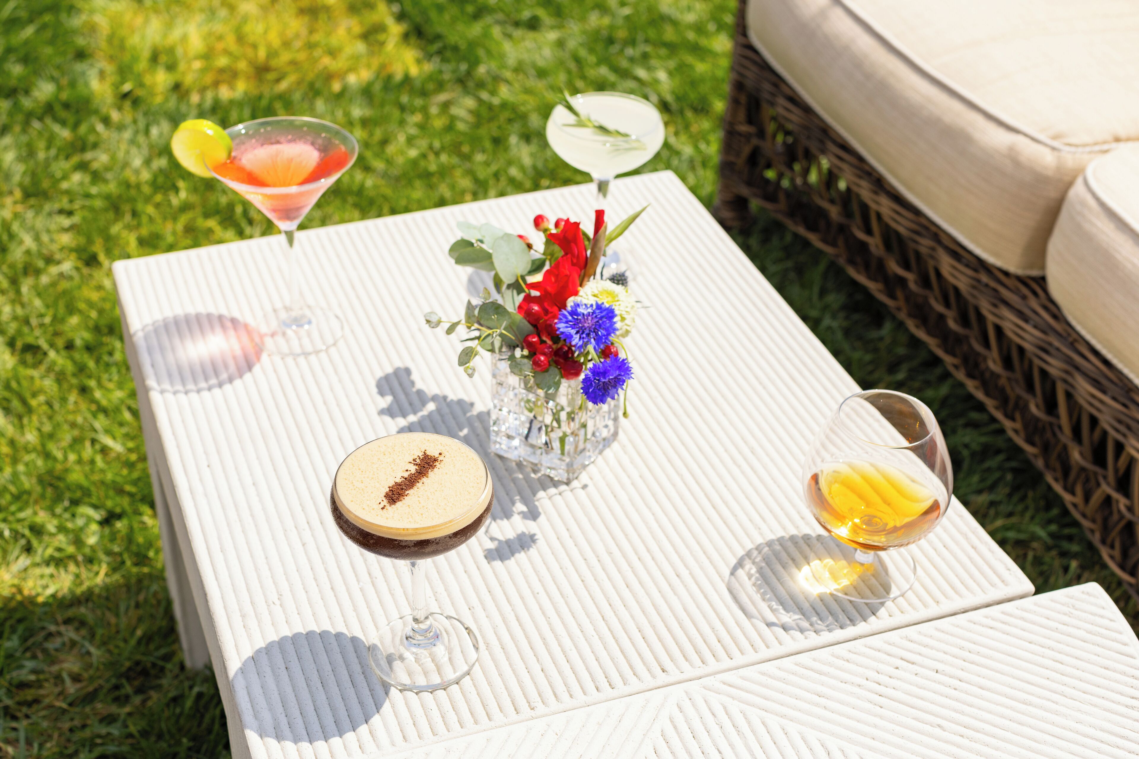 A table with a martini glass, a wine glass, and a dessert plate.