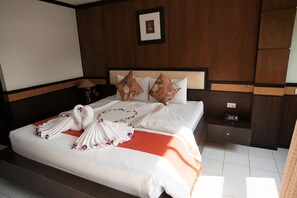 Habitación de hotel con una cama bien hecha, una mesita de noche con una lámpara y un cuadro en la pared.