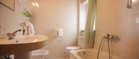 A bathroom with a sink, toilet, and bathtub.