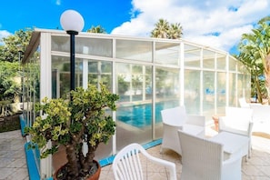 Piscine couverte, piscine extérieure, parasols de plage, chaises longues