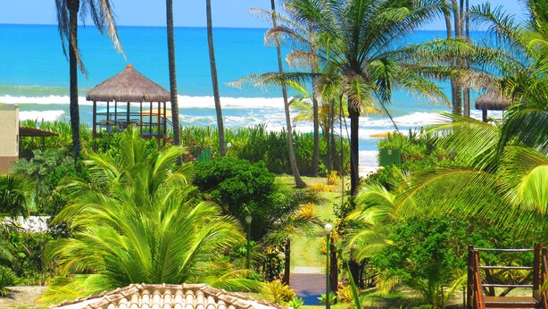 A tropical resort with a beach view, palm trees, and a gazebo. - Ilhéus North Hotel (Uruçuca)