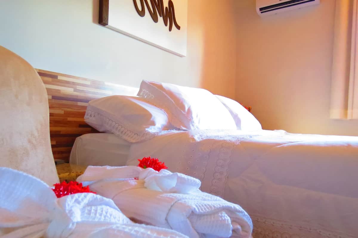 A hotel room with two beds, a wooden headboard, and a wall-mounted sign.