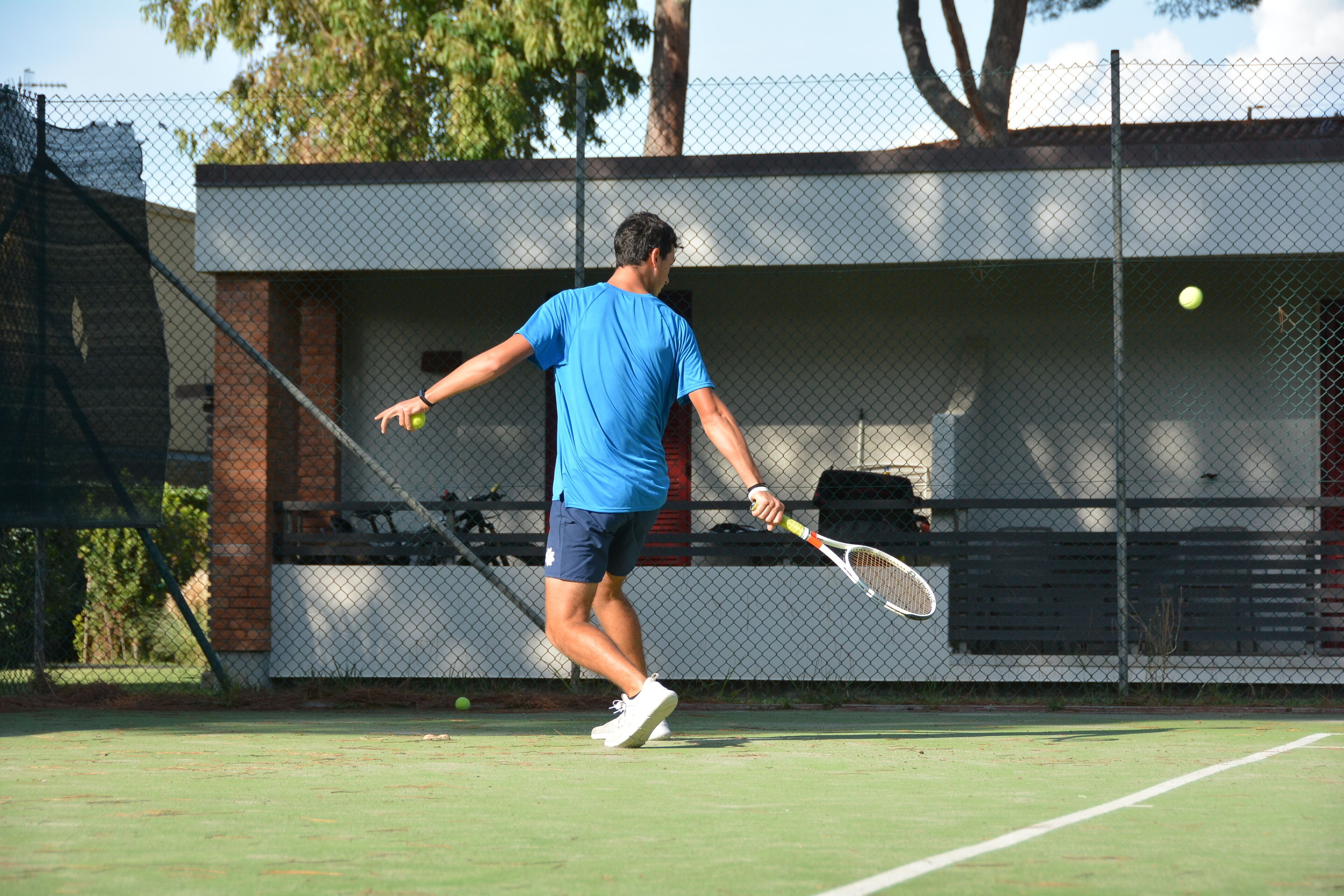 Un court de tennis avec un joueur portant un maillot et un short bleus.