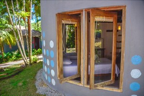 A room with a bed, a window, and a view of the outdoors.