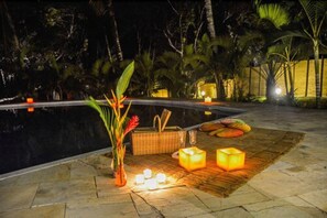 Una piscina al aire libre, sillones reclinables de piscina