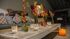 A room with a long table displaying various decorative items, including vases and candles. - Pousada Jacarandá (Porto Seguro)