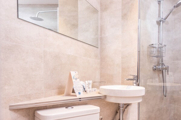 A modern bathroom with a white sink, a toilet, and a shower. - RVHotels GR92 (Torroella de Montgrí)