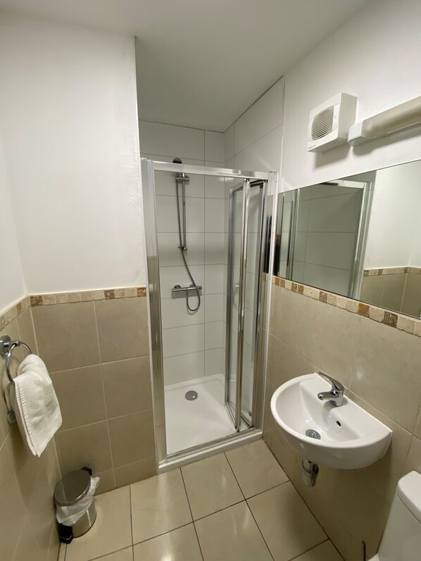 A modern bathroom with a glass-enclosed shower, a white sink, and a toilet. - Wendover Arms (High Wycombe)