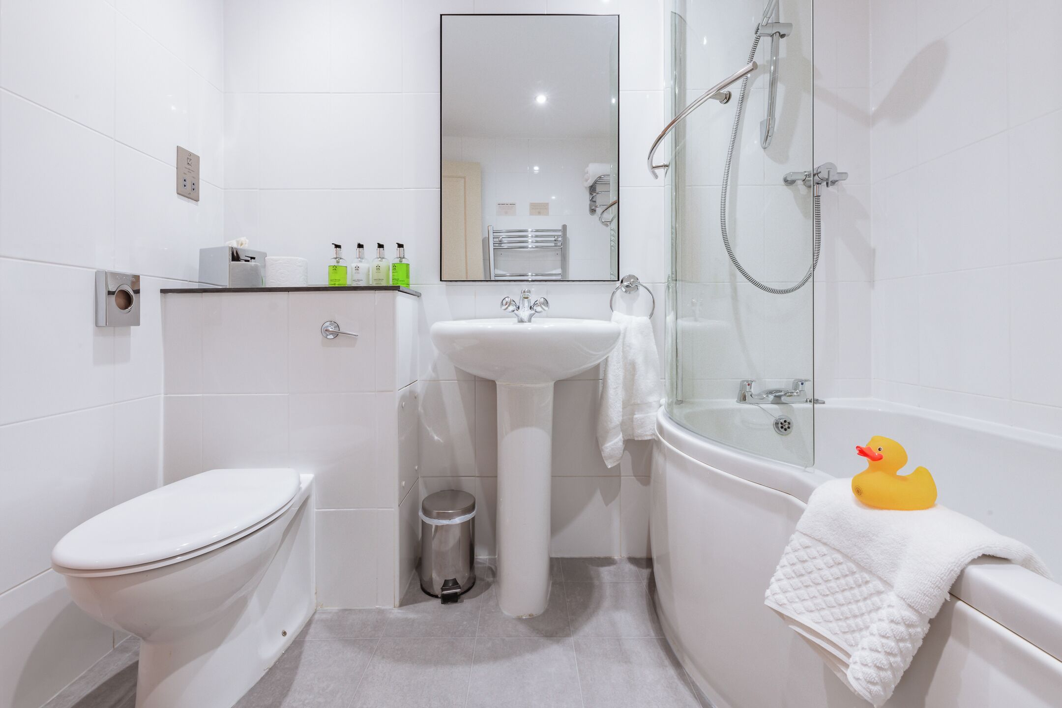 Ein modernes Badezimmer mit Toilette, Waschbecken und Badewanne.