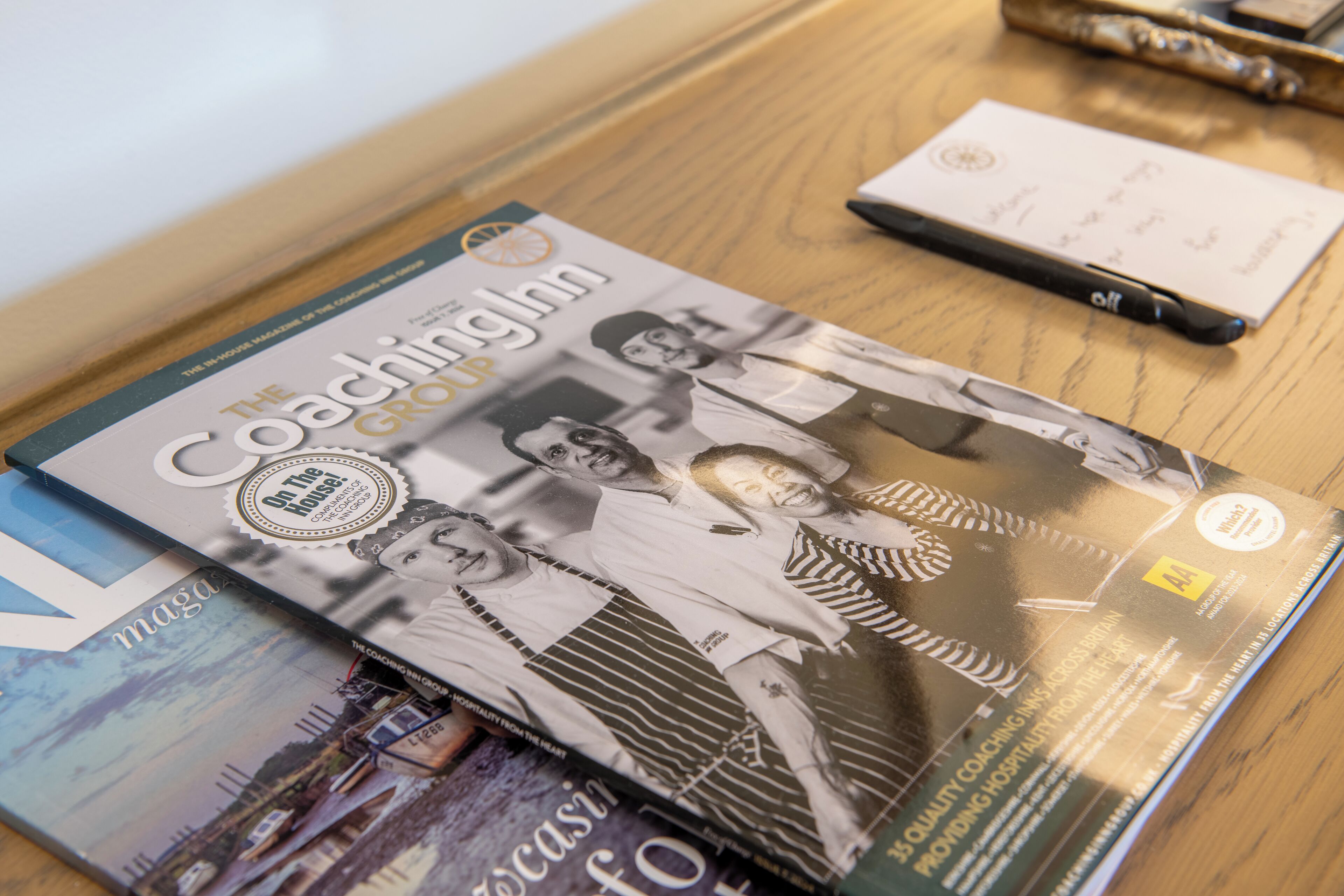Una revista titulada "The Coaching Inn" sobre una mesa de madera.