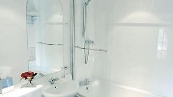 A modern bathroom with a glass shower enclosure, a sink, and a vanity with a mirror.