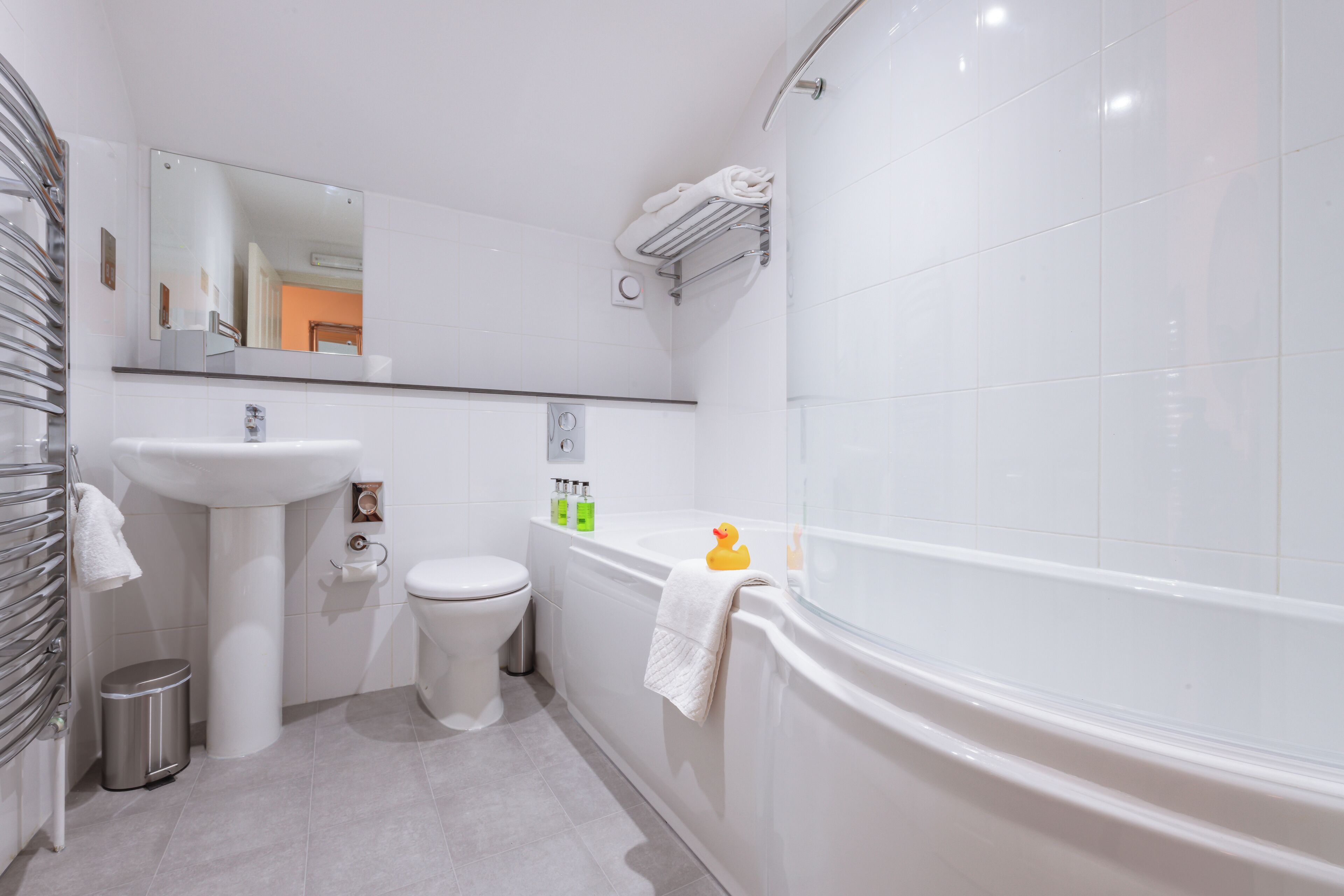A modern bathroom with a sink, toilet, and bathtub.