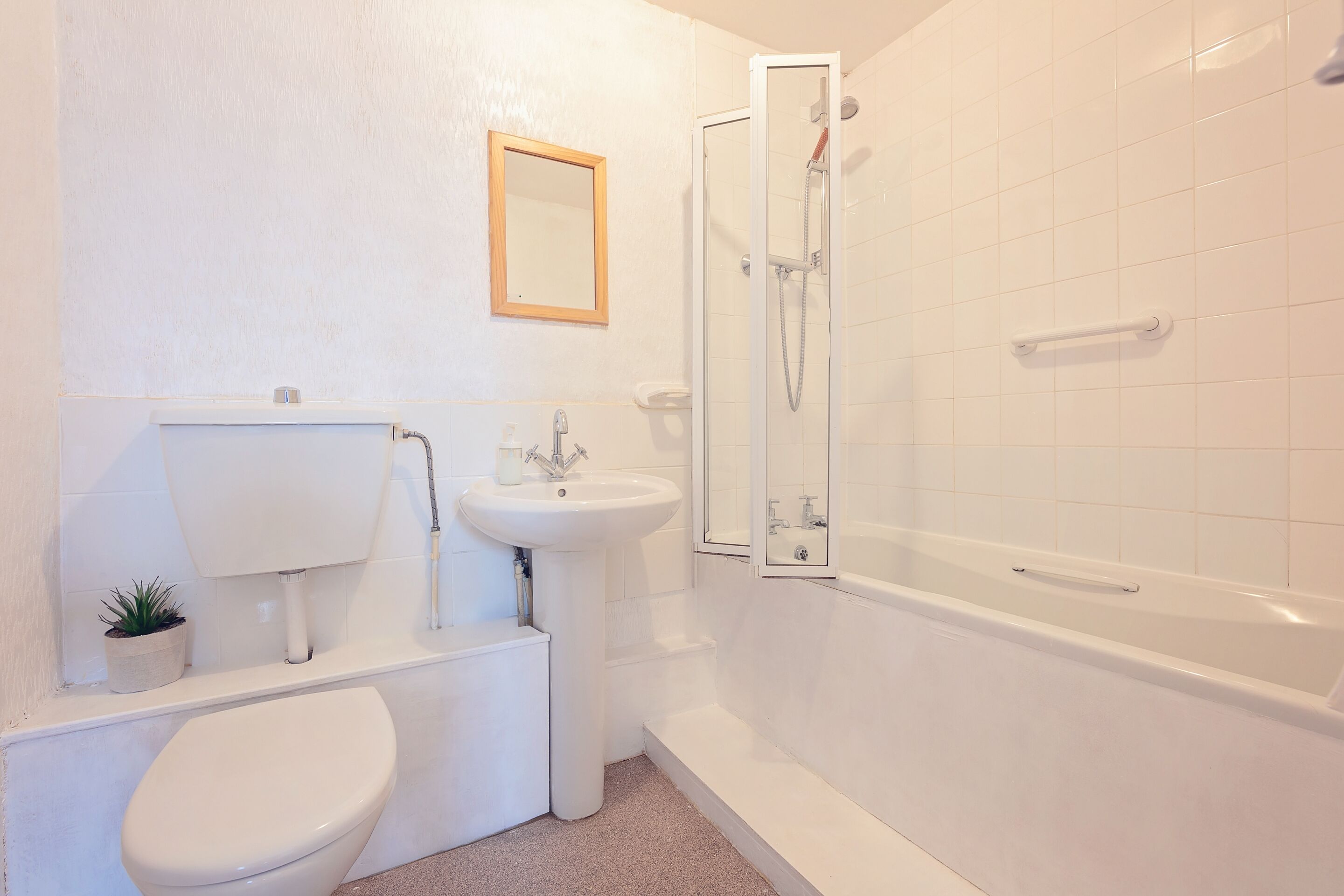 Un baño con inodoro, lavabo y ducha.