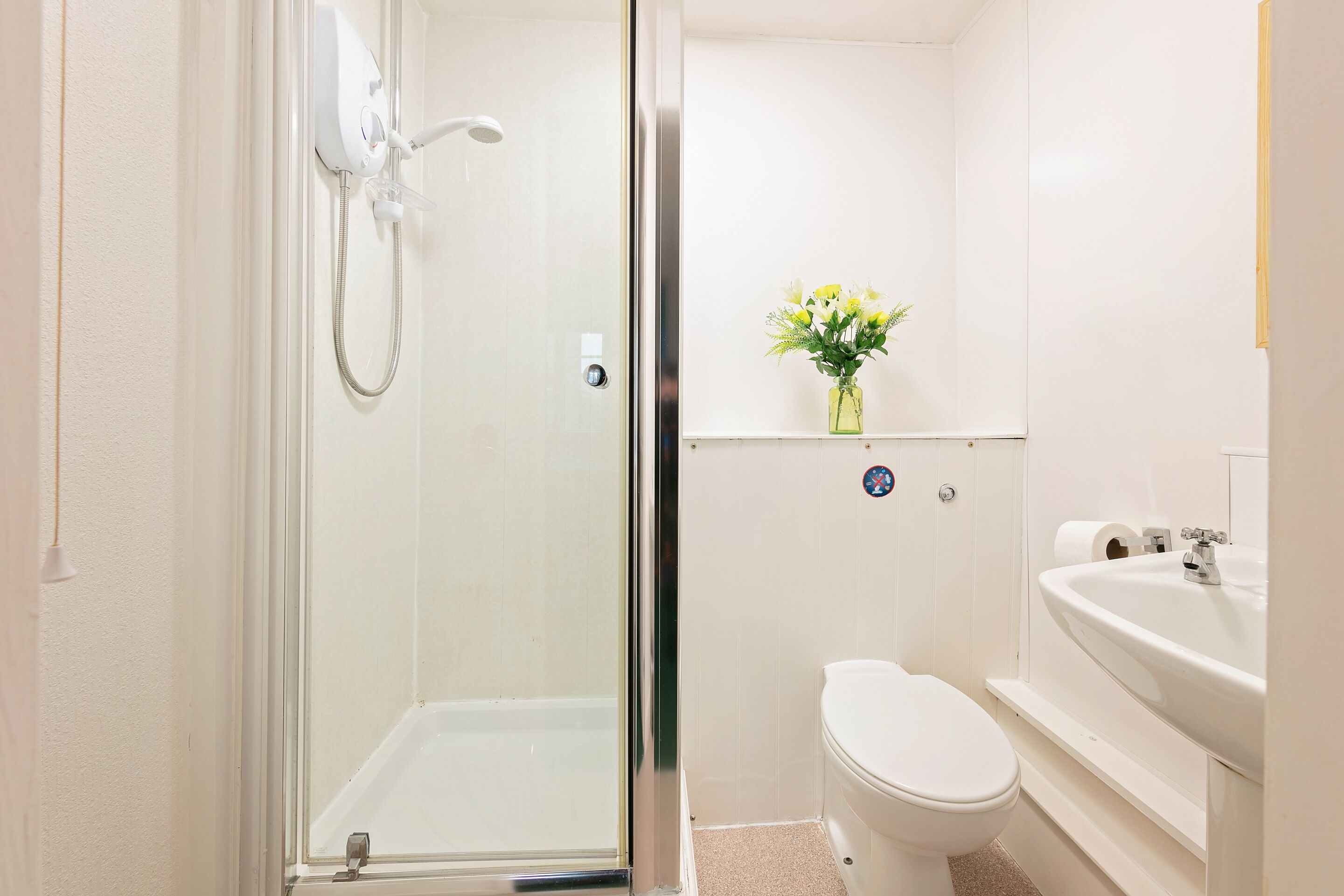 Une salle de bain avec une douche à parois de verre, des toilettes et un lavabo avec un miroir.