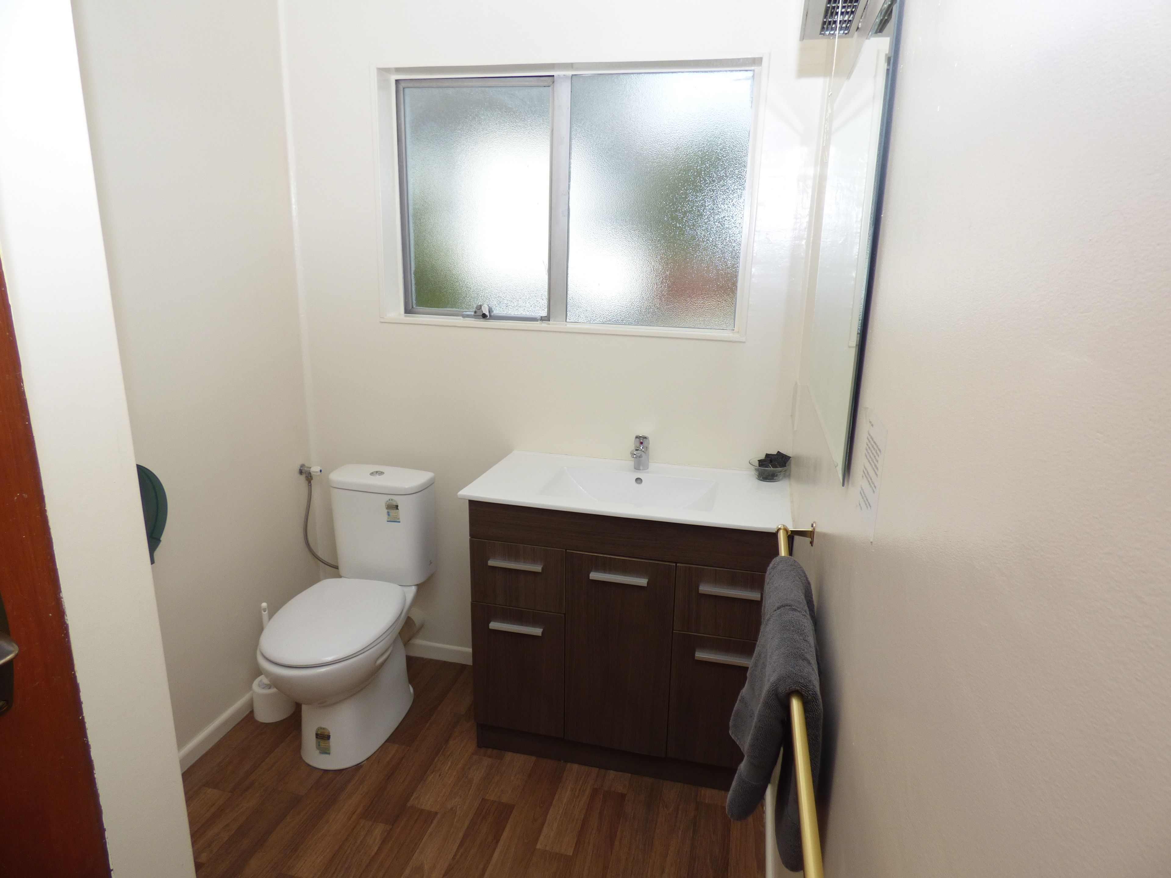Un baño pequeño con inodoro, lavamanos y ventana.