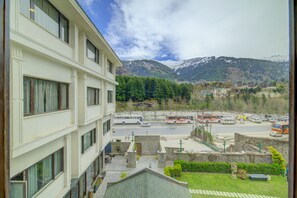 Un hôtel à plusieurs étages offrant une vue sur une rue et sur les montagnes.