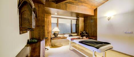 Un dormitorio con techo de madera, una cama, una mesita de noche, una lámpara y una ventana.