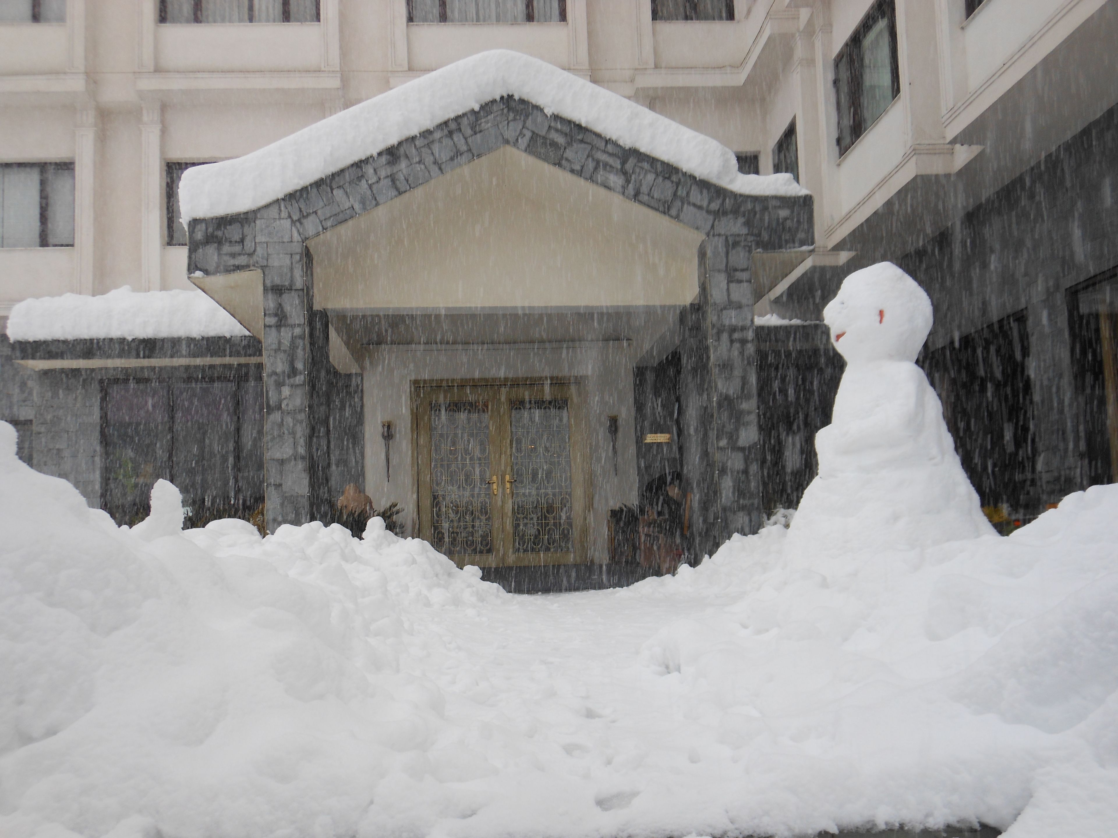 A building with a stone facade and a snow-covered entrance.
