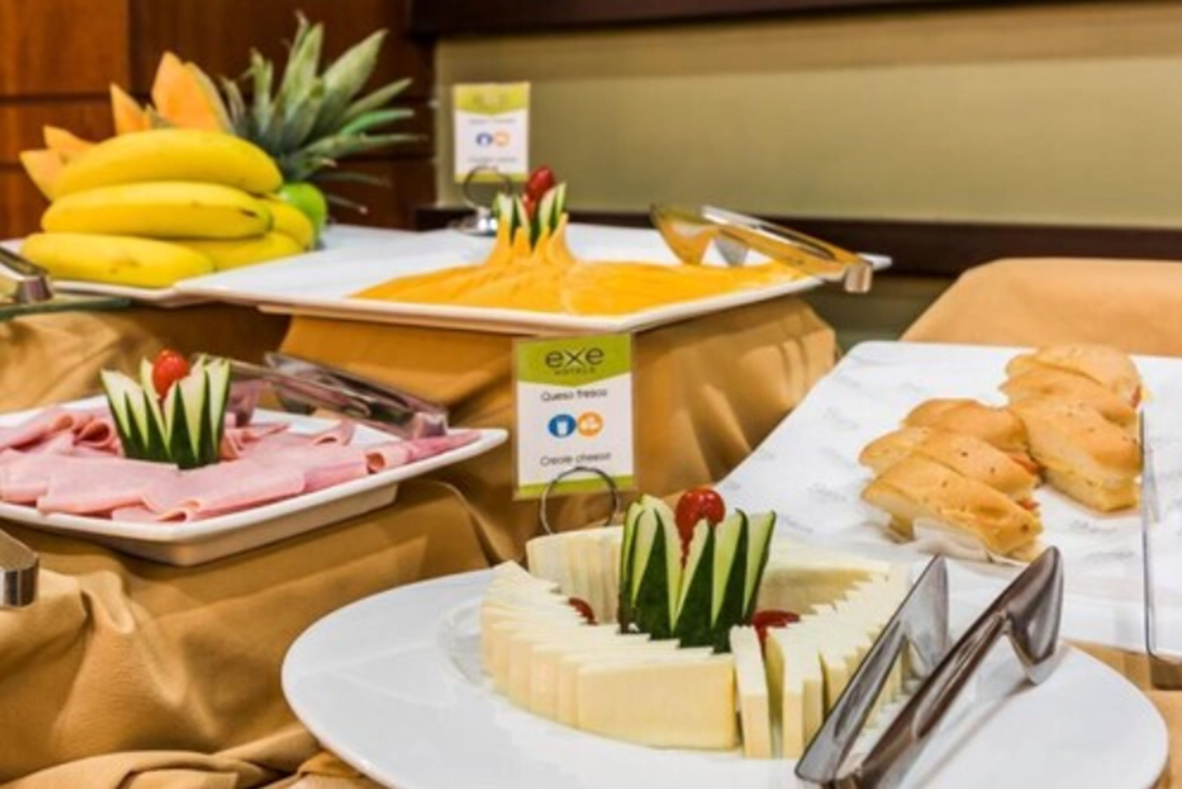 Ein reichhaltiges Buffet mit verschiedenen Speisen, darunter Käse, Obst und Brot.