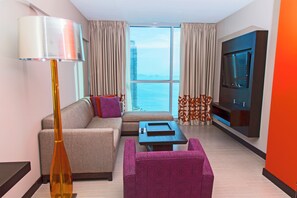 A modern hotel room with a sofa, armchair, and a television. - Megapolis Hotel Panamá (Panama City)