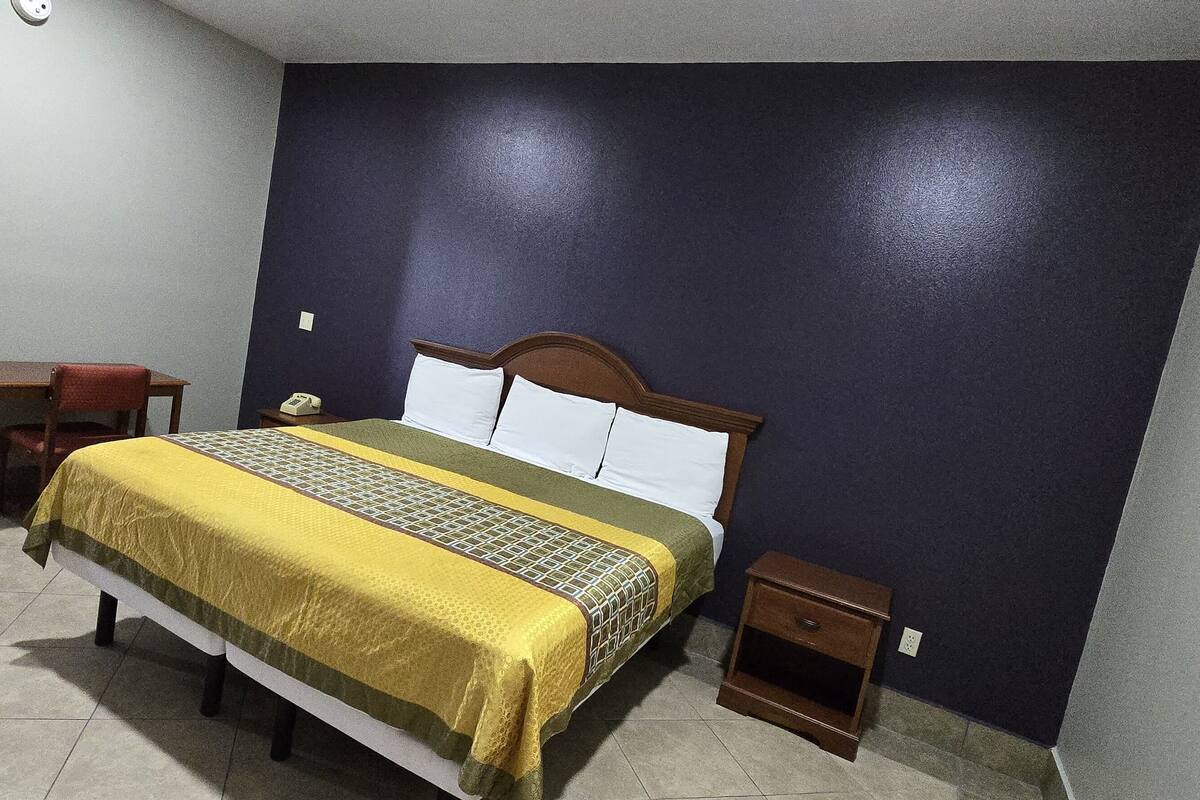 A bedroom with a bed, bedside table, and a nightstand.