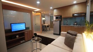 Een moderne woonkamer met een flatscreen televisie, een bank en een klein bijzettafeltje.